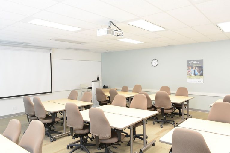 A view of training room 2 with a projector set up in a table group configuration